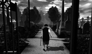 A black and white image of an old woman walking away from the player through a graveyard.